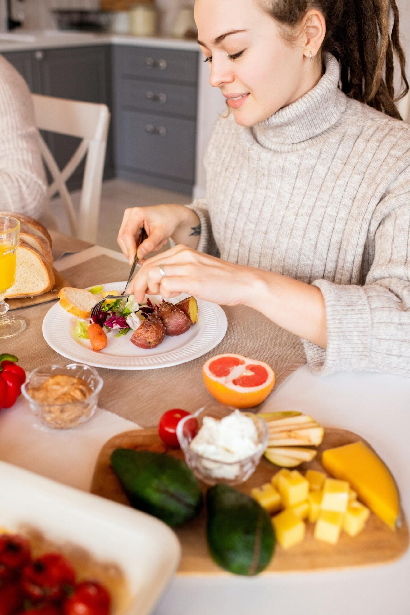 Una mujer sentada en una mesa comiendo platos saludables