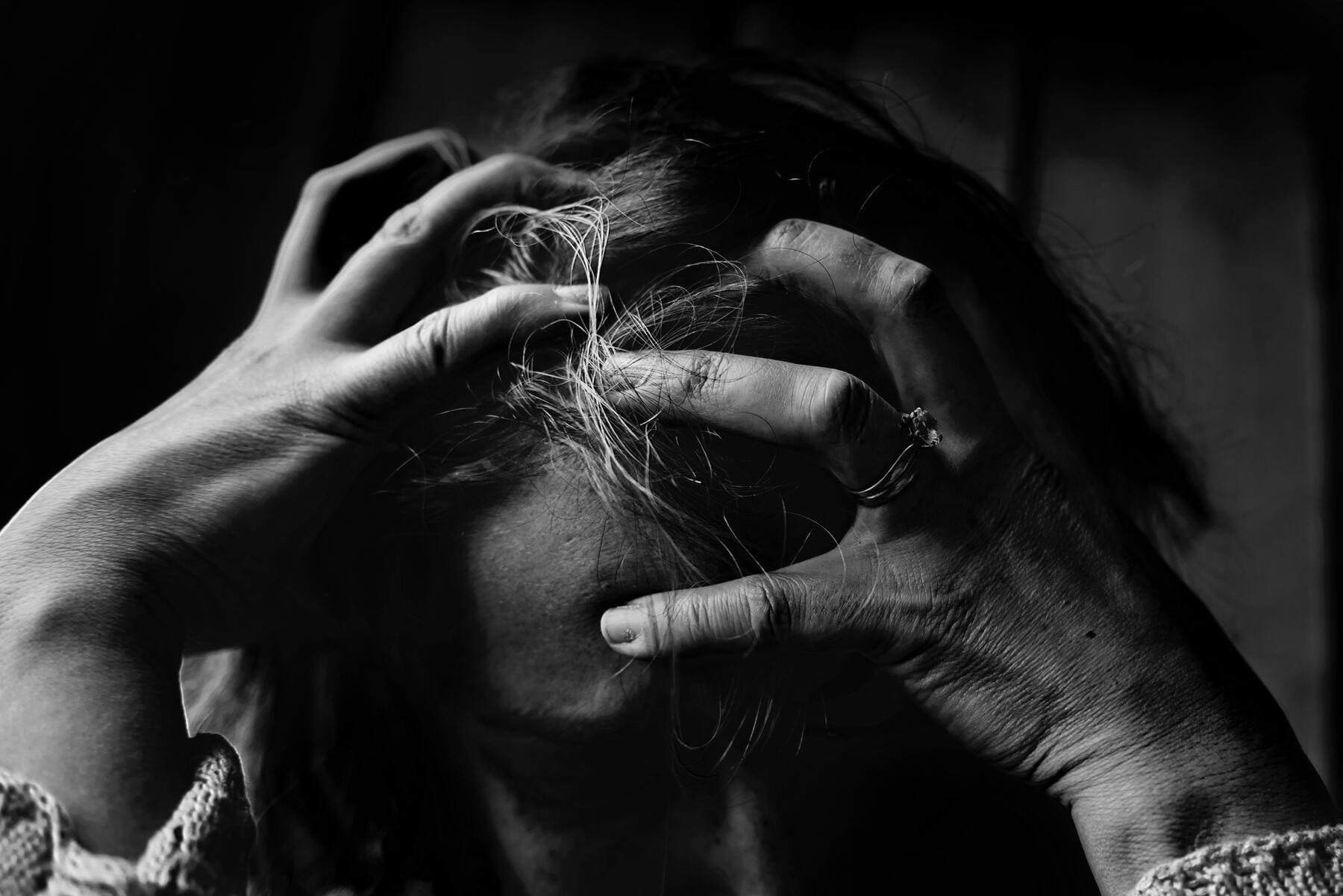 Una mujer con las manos en la cabeza en claro síntoma de desgaste.