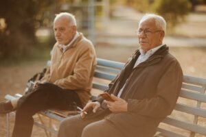 Dos abuelos están sentados en un banco y fuman
