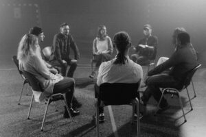 escena de participación en Grupos de Ayuda Mutua: personas sentadas en círculo debatiendo