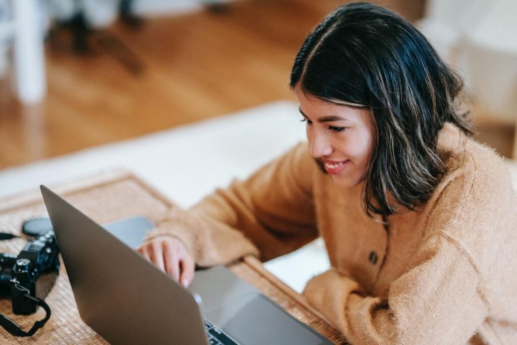 Mujer joven sonriente frente al ordenador