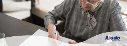 Una persona mayor firma un documento con el logo de Aiudo abajo a la derecha.